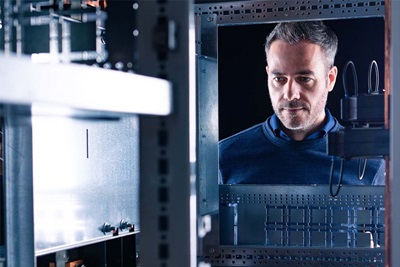 Professional examining an electrical cabinet with a focus on automation and control systems